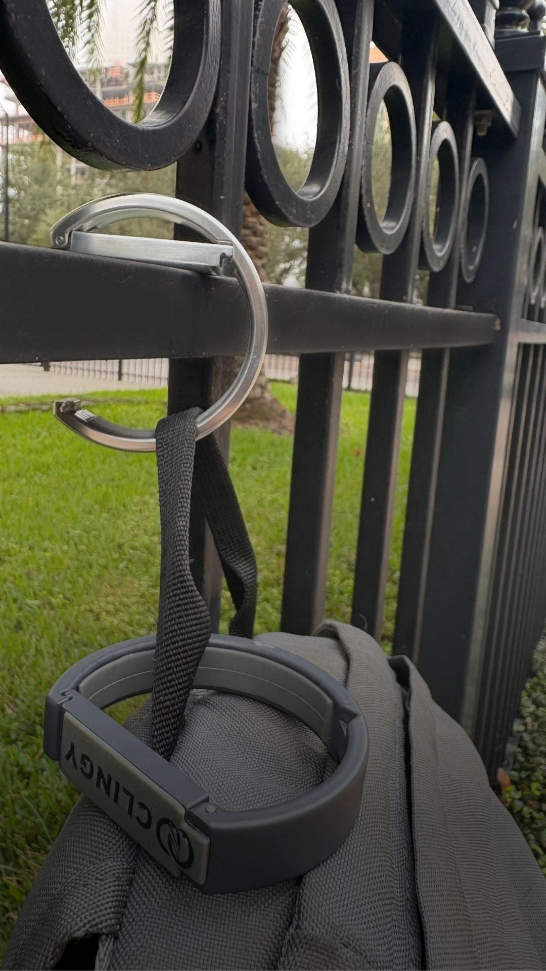 Clingy hook holding a bag off the floor on a fence.