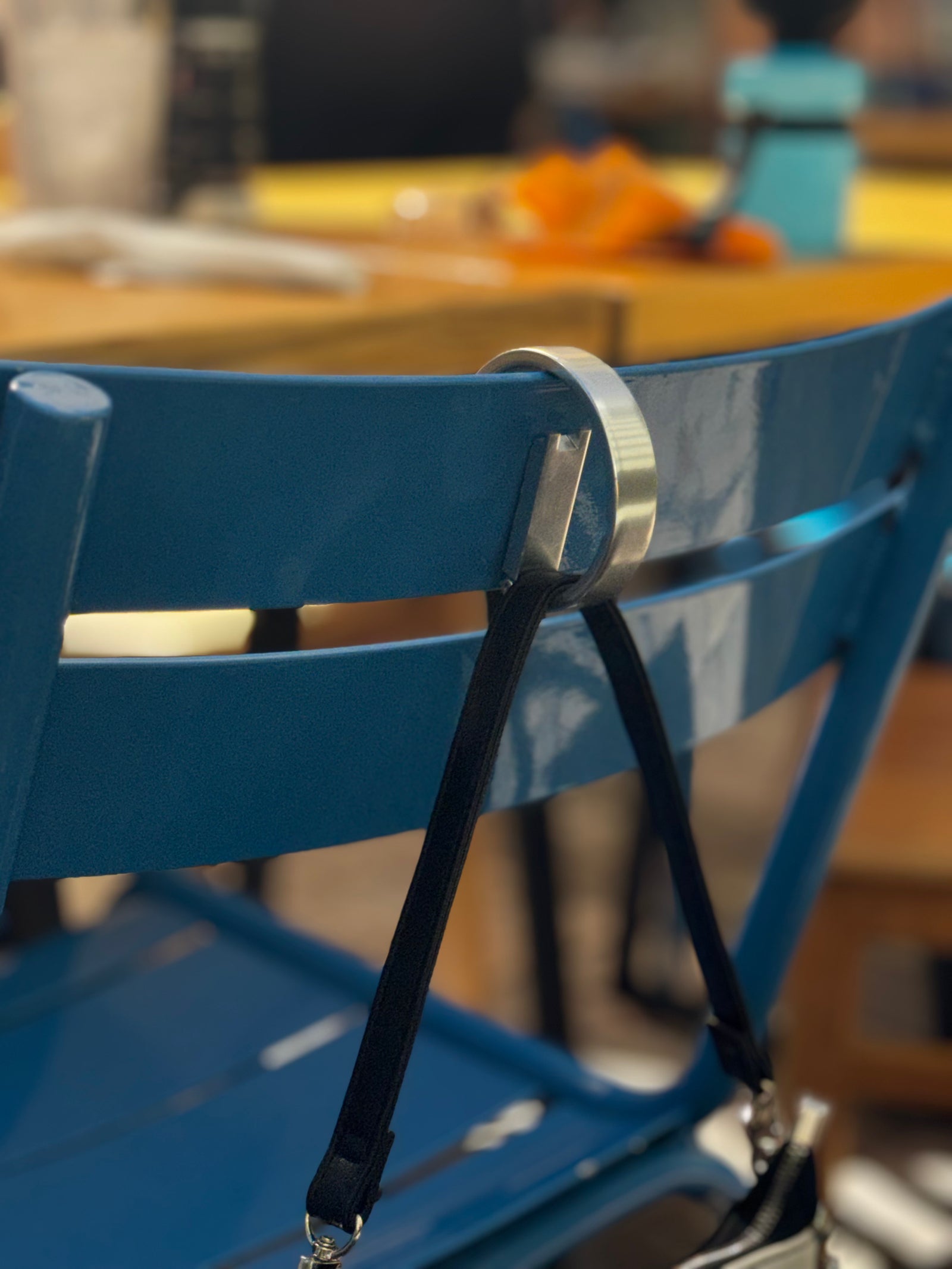 ClingyHook securing a bag to the back of a chair at an outdoor café