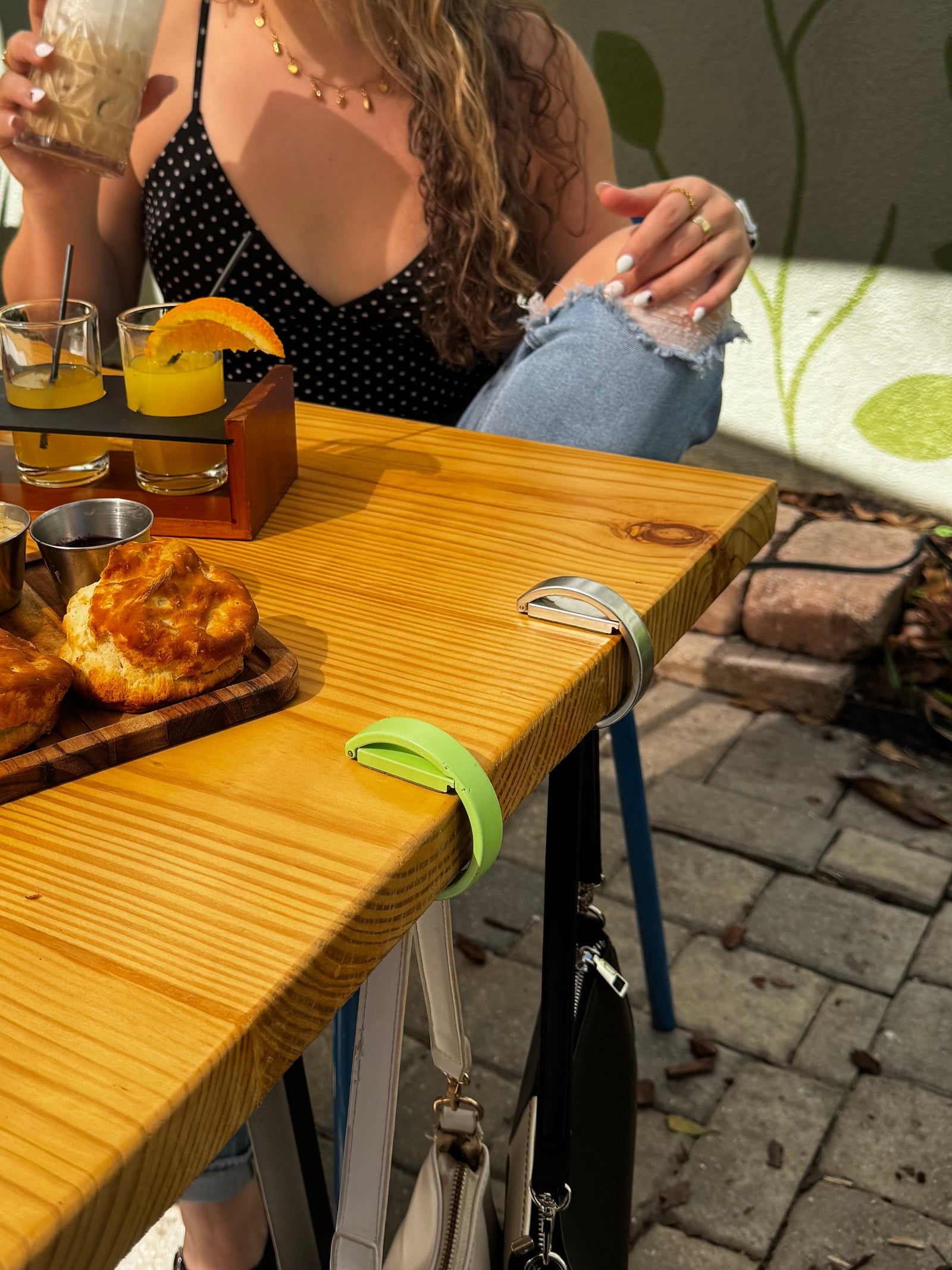 ClingyHook holding a bag on the edge of an outdoor restaurant table